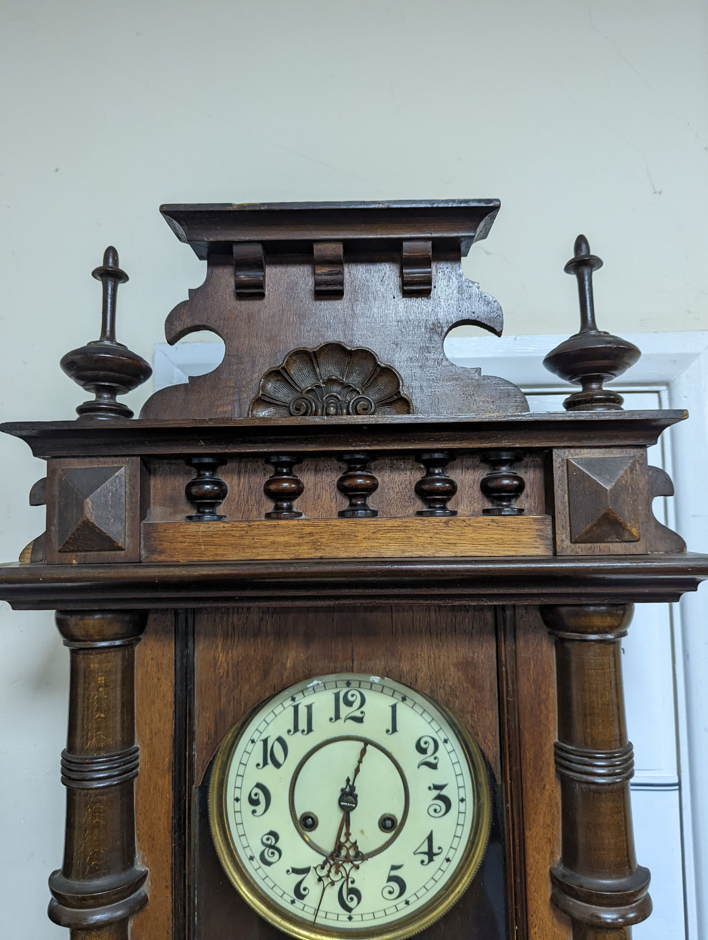 A late 19th century Austrian walnut wall clock, with key and pendulum, height 118cm